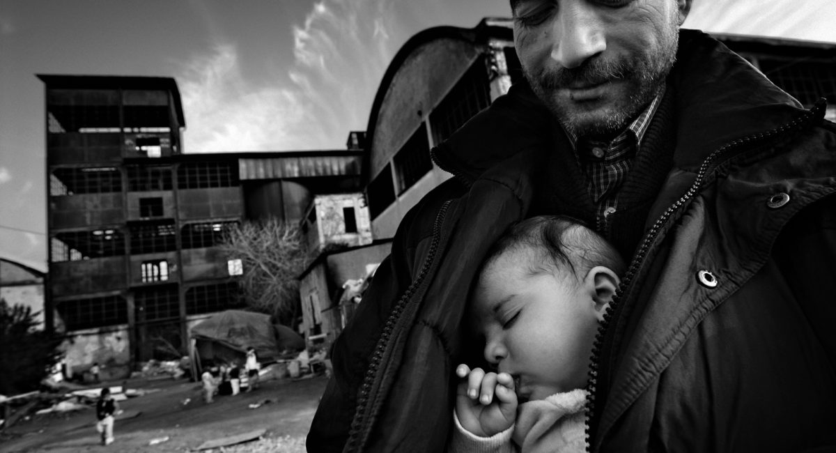 Rome, Italy.
Gypsy man with his grandchild sleeping in his arms. He built a little shack in the abandoned factory. Here, gypsies are mainly Rumanians.