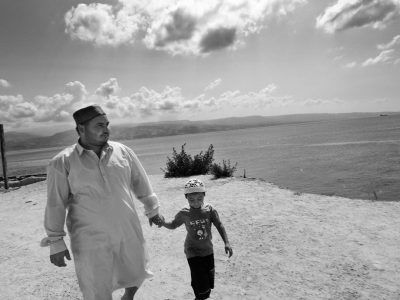 Arben, 26, gypsy man from Montenegro and one of his sons. Arben is the spiritual guide of gypsie muslim comunity inside "Fatima Village" roma camp. He wants to become a Dervish. Inside the camp he built a tekija, where he prays twice a day. He lives with his family inside "Fatima Village" roma camp is built next to the straight of Messina. Gypsies living conditions in Italy is always very tough. It's very difficult for them to get a regular job and a proper house, because of prejudice against them.