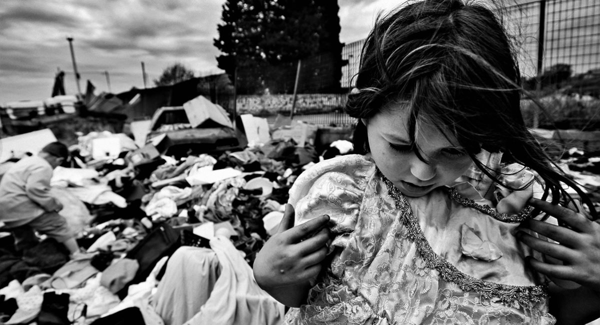 Rome, Italy.
A gypsy child found a beautiful dress in the garbage, on the street near a Sunday market in Rome.